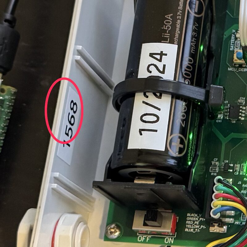 Inside the logger enclosure: a small white label reading 1568 on the wall beside the battery, circled in red