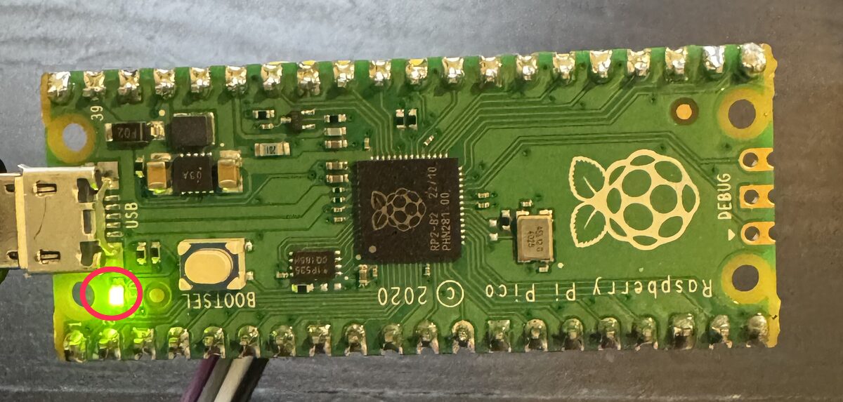 The updater board with its small green light lit solid, circled in red — the finished-and-successful signal